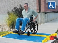 man in wheel chair easily crossinng linebacker cable protector with blue ada ramp kit attached